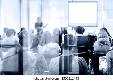 Speaker Giving A Talk At Business Meeting. Audience In The Conference Hall. Business And Entrepreneurship. Trough The Glass Door Look.