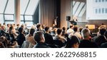Speaker giving a talk in conference hall at business event. Rear view of unrecognizable people in audience at the conference hall. Business and entrepreneurship concept