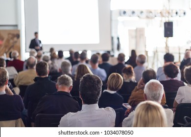 Redner, der bei einer geschäftlichen Veranstaltung im Konferenzsaal spricht. Publikum im Konferenzsaal. Konzept der Unternehmen und des Unternehmertums. Konzentriere dich auf einen unerkennbaren Mann im Publikum.
