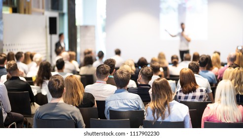 Speaker giving talk in conference hall at business event  Audience at the conference hall  Business   Entrepreneurship concept  Focus unrecognizable people in audience 