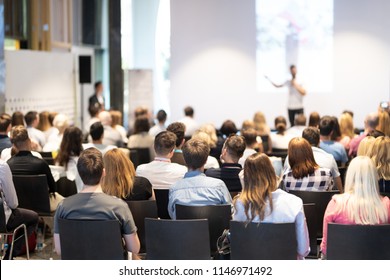 Speaker giving a talk in conference hall at business event. Audience at the conference hall. Business and Entrepreneurship concept. Focus on unrecognizable people in audience. - Shutterstock ID 1146971492