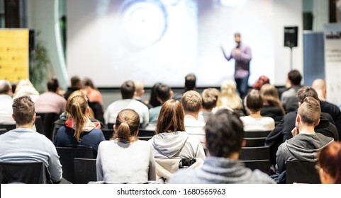 Speaker giving a talk in conference hall at business event. Rear view of unrecognizable people in audience at the conference hall. Business and entrepreneurship concept. - Shutterstock ID 1680565963