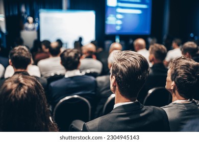 Speaker giving a talk in conference hall at business event. Rear view of unrecognizable people in audience at the conference hall. Business and entrepreneurship concept - Shutterstock ID 2304945143