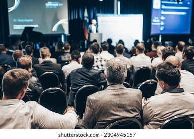 Speaker giving a talk in conference hall at business event. Rear view of unrecognizable people in audience at the conference hall. Business and entrepreneurship concept - Shutterstock ID 2304945157