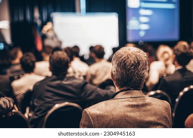 Speaker giving a talk in conference hall at business event. Rear view of unrecognizable people in audience at the conference hall. Business and entrepreneurship concept - Shutterstock ID 2304945163