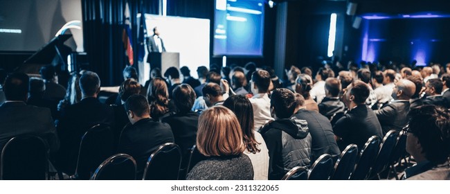 Speaker giving a talk in conference hall at business event. Rear view of unrecognizable people in audience at the conference hall. Business and entrepreneurship concept - Shutterstock ID 2311322065