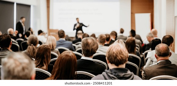 Speaker giving a talk in conference hall at business event. Rear view of unrecognizable people in audience at the conference hall. Business and entrepreneurship concept - Powered by Shutterstock