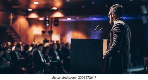 Speaker giving a talk on corporate business conference. Unrecognizable people in audience at conference hall. Business and Entrepreneurship event. - Shutterstock ID 2308572647