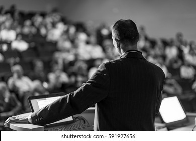 Speaker Giving A Talk On Corporate Business Conference. Audience At The Conference Hall. Business And Entrepreneurship Event. Black And White Image.