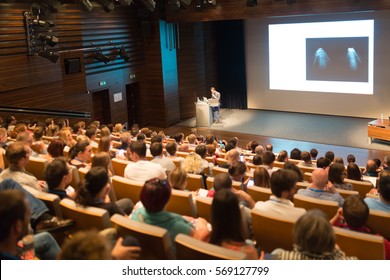 Speaker giving a talk on scientific conference. Audience at the conference hall. Business and Entrepreneurship concept. - Shutterstock ID 569127799