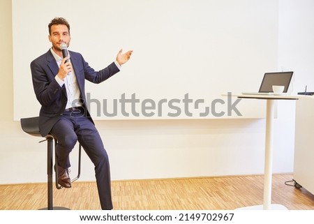 Speaker with microphone gives lecture and presentation at business conference