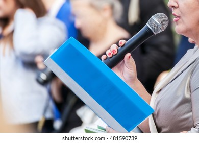 Speaker with microphone in hand at meeting closeup - Powered by Shutterstock