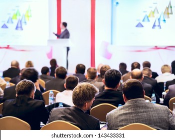 Speaker On The Podium. People At The Conference Hall. Rear View