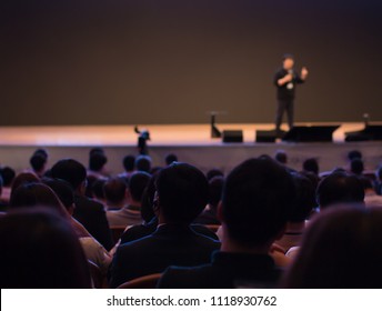 Speaker On Stage Presenting At Event. Audience At Conference Hall Lecture Series. Corporate Technology Investors. Tech Managers Pitch. Blurred De-focused.