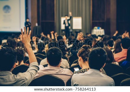 Speaker on the stage with Rear view of Audience in the conference hall or seminar meeting, business and education concept