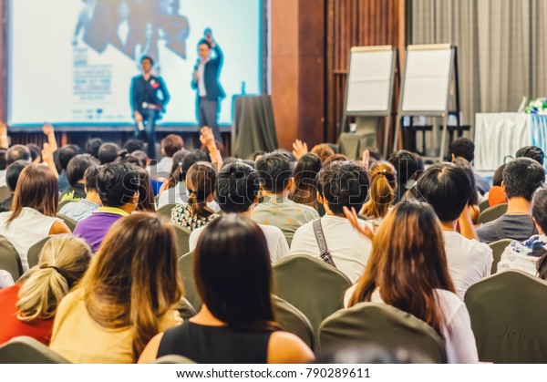 Speaker\
on the stage with Rear view of Audience in the conference hall or\
seminar meeting, business and education\
concept