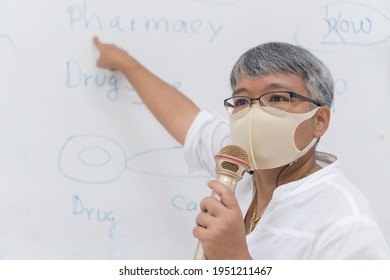 Speaker Professor Female Asian Teaching Explain Wear Medical Face Mask For Safety Speaking Microphone At Whiteboard In Classroom In University. Teacher In Health Care Prevent COVID-19 Disease Epidemic