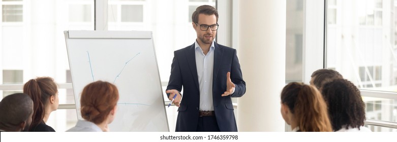 Speaker talking to audience makes presentation using flip chart interacts with group of staff employees, corporate seminar, training activity concept. Horizontal photo banner for website header design - Shutterstock ID 1746359798