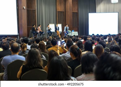 Speakers On The Stage With Rear View Of Audience In The Conference Hall Or Seminar Meeting, Business And Education Concept