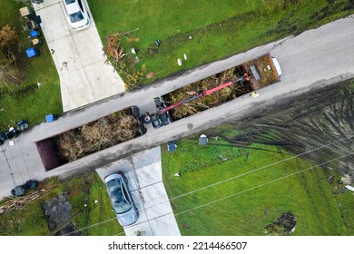 Special Aftermath Recovery Dump Truck Picking Up Vegetation Debris From Suburban Streets After Hurricane Ian Swept Through Florida. Dealing With Consequences Of Natural Disaster