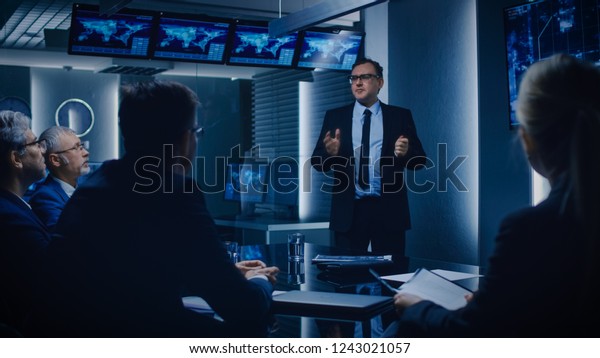 Special Agent in Charge Shows Satellite\
Surveillance Footage of the Car Getaway to a Team of Government\
Agents. GPS Tracking Fugitive in the Big Monitoring Room Full of\
Computers with Animated\
Screens