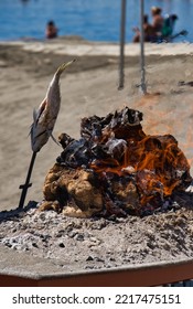 Special Andalusian Barbecue On A Sunny Day. Espeto, Grilled Fish Outdoors. Grilling Fish On The Sandy Beach. Typical Andalusian Dish. Spanish Cover.