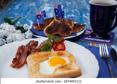 A special Australia Day, 26th January, breakfast with bacon, fried tomato, egg, and  toast in the shape of Australia with the iconic Australian savoury spread, vegemite.