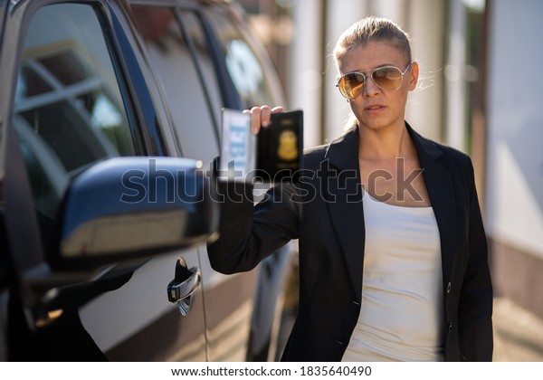 Special federal intelligence agent woman in black\
suit and big police car