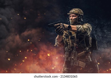 Special force soldier aiming pistol against explosions and fire