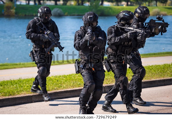 Special forces tactical team of four in action,\
unmarked and unrecognizable swat\
team