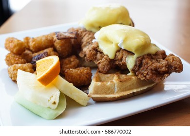 Special Fried Chicken And Waffles With Eggs Benedicts On Top With A Side Of Tater Tots