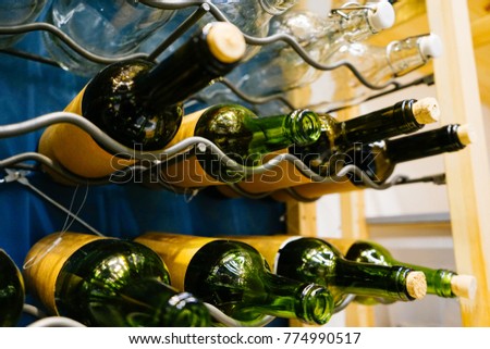 In a special metal stand lie empty and full wine bottles