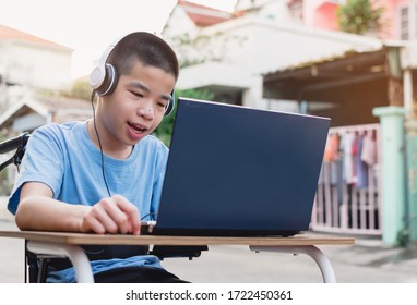 Special Need Child On Wheelchair Happy Time To Use A Notebook In The House, Study And Work At Home For Safety From Covid 19, Life In The Education Age Of Special Need Kid, Happy Disabled Boy Concept.