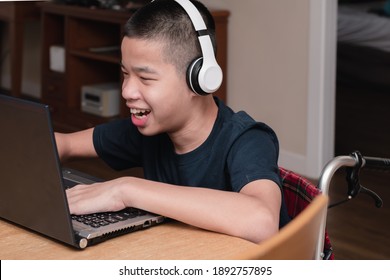 Special need child on wheelchair happy time to use a notebook in the house, Study and Work at home for safety from covid 19, Life in the education age of special need kid, Happy disabled boy concept. - Powered by Shutterstock