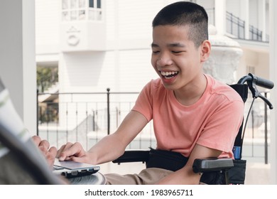 Special Need Child On Wheelchair Using Computer In The House With His Parent, Study Or Work At Home For Safety From Covid 19, Life In New Normal Education Of Disability Kid,Happy Disabled Boy Concept.