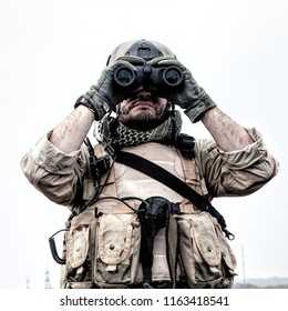 Special Operations Forces Soldier, Navy SEAL Scout In Battle Uniform And Helmet, Looking Through Binoculars, Observing Area, Searching Targets, Monitoring Enemy Movements, Directing Artillery Fire