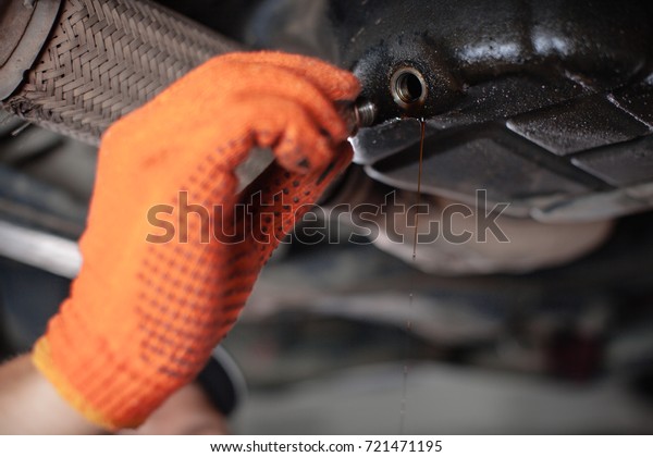 Specialist auto mechanic in the car service repairs\
the car. Change of\
oil.