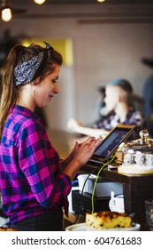 Specialist Coffee Shop A Woman Working Behind The Counter Using The Touch Screen On The Till