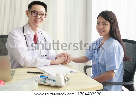 Specialist Doctor reassuring to Young Asian female patient comforting and trusting, explaining, giving a consultation to medical information and diagnosis about treatment. Medical insurance concept.