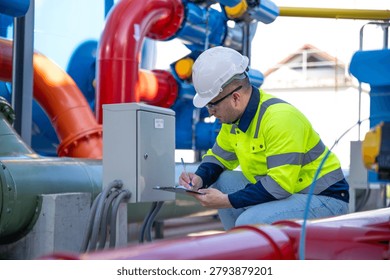 A specialist engineer is inspecting the structural integrity of the water tank and high-pressure pipes.