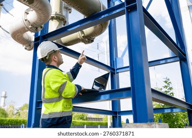 A specialist engineer is inspecting the structure of a large water pipeline between industrial plants.