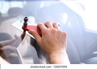 Specialist Fixing Crack On Car Windshield In Repair Shop