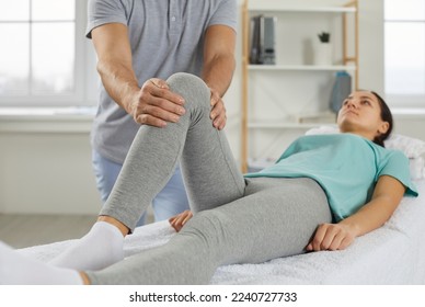 Specialist at modern physiotherapy room or rehabilitation center examining and helping young woman who has knee pain. Professional physical therapy, treatment, and rehabilitation after injury concept - Powered by Shutterstock