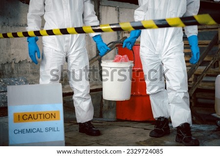Specialist Officers in Chemical Safety Wear Chemical Risk Protective Clothing for Chemical Spill Cleanup and Recovery in Carrying a Bucket, Industrial Waste Cleanup and Environmental Safety.