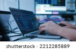 specialist programmer man hand type configuration code on at laptop for check software function for fix bug and defect of security system in dark datacenter room for engineering and technology concept