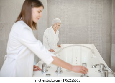 Specialist in spa salon getting the bath for hydromassage ready