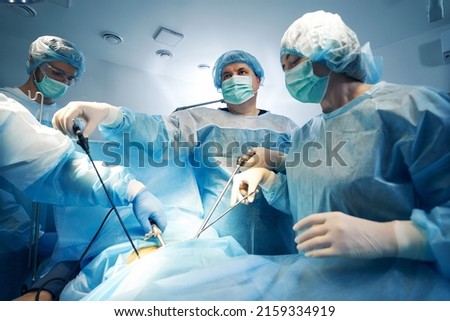 Specialist in surgery using laparoscopic tools while operating on patient