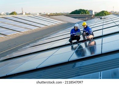 Specialist technician professional engineer with laptop and tablet maintenance checking installing solar roof panel on the factory rooftop under sunlight. Engineers team survey check solar panel roof. - Powered by Shutterstock