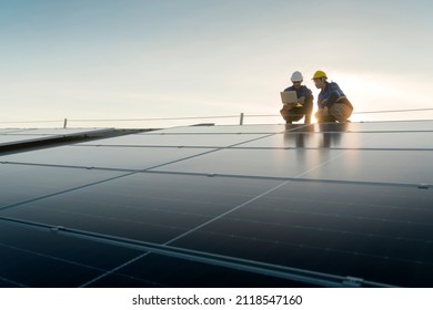 Specialist technician professional engineer with laptop and tablet maintenance checking installing solar roof panel on the factory rooftop under sunlight. Engineers team survey check solar panel roof.