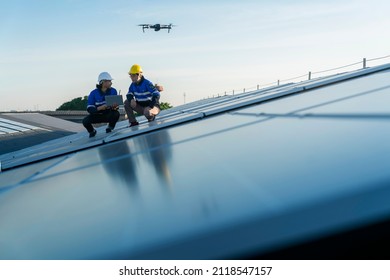 Specialist Technician Professional Engineercontrol Drone Checking Top View Of Installing Solar Roof Panel On The Factory Rooftop Under Sunlight. Engineers Holding Tablet Check Solar Roof.